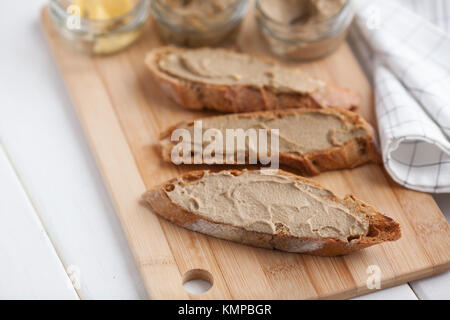 Pane con carne di vitello e patè di coniglio con burro su una scheda di bambù. Foto Stock