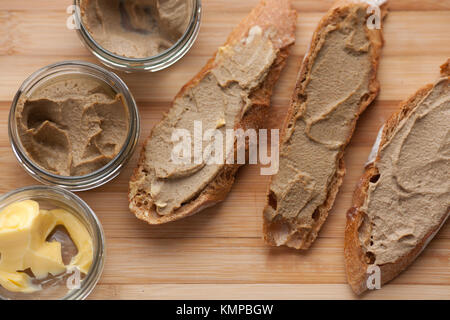 Pane con carne di vitello e patè di coniglio con burro su una scheda di bambù. Vista dall'alto. Foto Stock