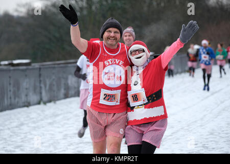 Preston, Regno Unito. Il 9 dicembre 2017. Regno Unito Meteo. I corridori braved nevischio e luce neve per raccogliere fondi per battere il cancro intestinale in onore di Ben Ashworth morto nel luglio dopo una battaglia con il cancro. Molti corridori indossati abiti fantasiosi e gonfiabili bum guance per la corsa intorno a Preston's Avenham e parchi di Miller. Ben Ashworth morì dopo cinque anni di battaglia con il cancro dell'intestino. Egli regolarmente addestrati per la sua maratona corre sulla Guild ruota che corre attraverso il parco. Credito: Paolo Melling/Alamy Live News Foto Stock