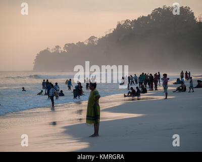 Silhouette di persone al tramonto nella spiaggia di Radhanagar, Havelock Foto Stock