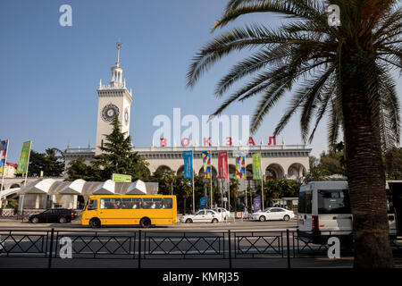 I mezzi di trasporto pubblico su Gorky Street e la stazione ferroviaria edificio nel centro della città di Sochi, Regione Krasnodar, Russia Foto Stock