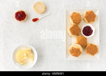 Pane appena sfornato scones, clotted cream e confettura di fragole in marmo bianco con sfondo spazio copia. Foto Stock