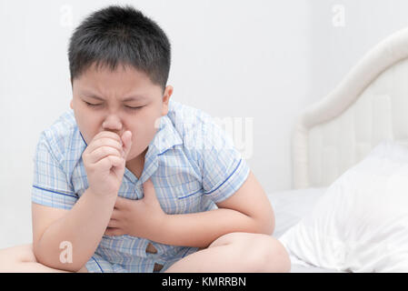 Ammalati obesi boy è la tosse e gola infezione sul letto, health care concept Foto Stock