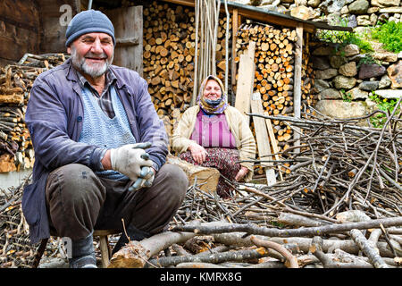 Anziana coppia turca sorridente e guardando mentre si trita il fuoco di legna a Trabzon, Turchia. Foto Stock