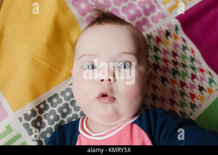 Ritratto di overhead di bambina giacente sul letto Foto Stock