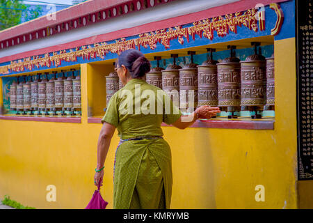 POKHARA, Nepal - 06 ottobre 2017: pilgrin non identificato di toccare la ruota pregando nel tempio tibetano, Padum, Kashmir India Foto Stock