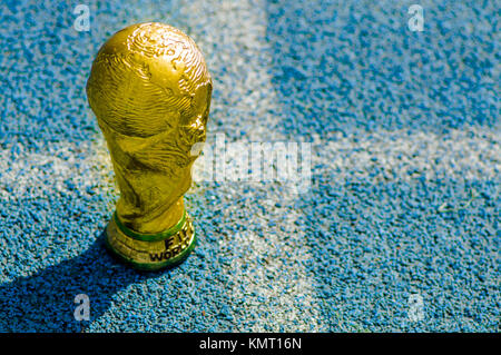 Close up fake golden trophy nella forma del mondo oltre una plastica blu materiale riciclato a all'aperto Foto Stock