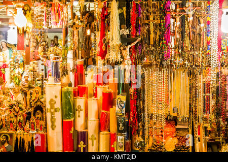 QUITO, Ecuador Novembre, 28, 2017: Close up di alcune candele, rosario i fagioli e artigianato in un mercato pubblico e al centro storico della città vecchia di Quito in Ecuador settentrionale Foto Stock