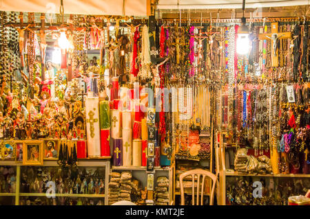 QUITO, Ecuador Novembre, 28, 2017: Close up di alcune candele, rosario i fagioli e artigianato in un mercato pubblico e al centro storico della città vecchia di Quito in Ecuador settentrionale Foto Stock