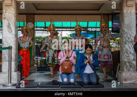 Bangkok, Tailandia. Santuario di Erawan. Donatori pregare mentre ballerini eseguono la danza come una benedizione. Foto Stock