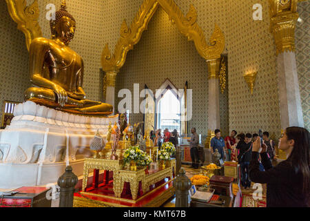 Bangkok, Tailandia. Adoratori di mescolarsi con i turisti al Wat Traimit, Tempio del Buddha d'oro. Il Buddha si siede nel gesto Bhumisparsha, cal Foto Stock