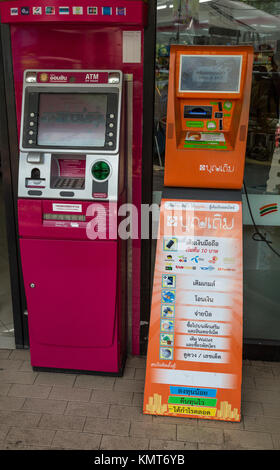 Bangkok, Tailandia. Macchina ATM sulla sinistra, scheda del telefono ricaricare la macchina sulla destra. Foto Stock