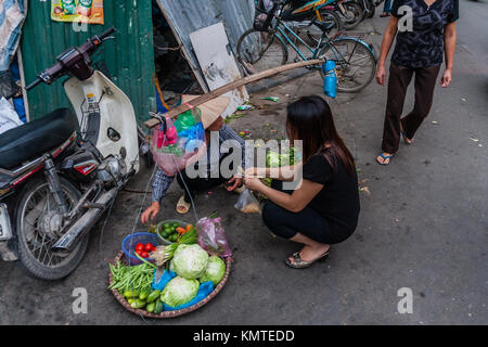 Una donna vietnamita la vendita di cibo di strada ad Hanoi, Vietnam Foto Stock