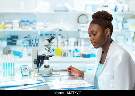 Scienziato africani, medico lavoratore, tech o studente laureato lavora in un moderno laboratorio biologico Foto Stock