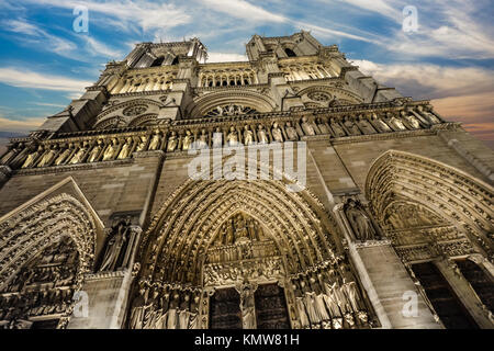 La facciata della Cattedrale di Notre Dame a Parigi Francia, guardando verso l'alto con un colorato tardo pomeriggio sky Foto Stock