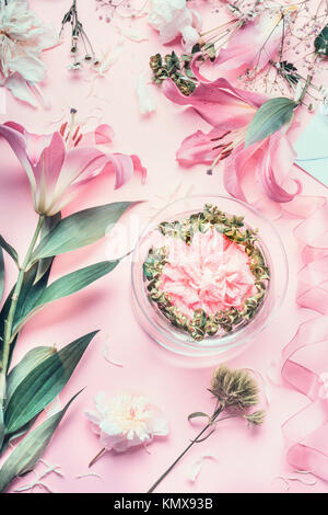 Rosa fioraio workspace con gigli e altri fiori vaso di vetro con acqua. Fiori di festosa regime rendendo, vista dall'alto Foto Stock