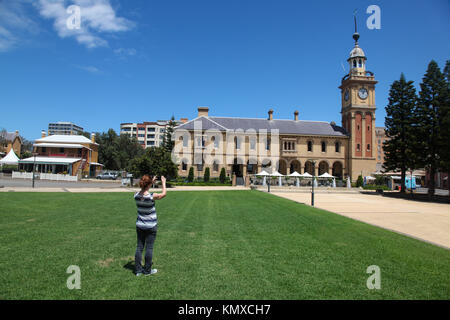 Una donna prende una foto della casa doganale un punto di riferimento locale in Newcastle - Australia la seconda città più antica. Foto Stock