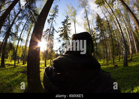 Forester vestiti di nero passando attraverso la foresta Foto Stock