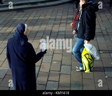 Suora cattolica sulla strada in cerca di carità donazione può scuotendo i passanti dalla città di Glasgow, Scotland, Regno Unito Foto Stock