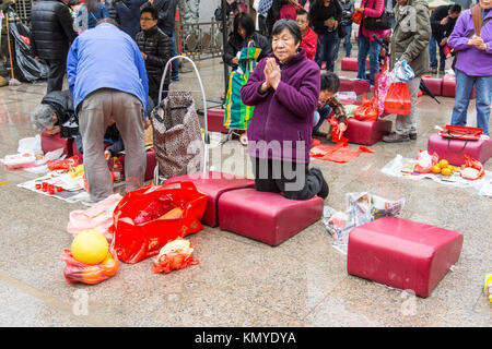 Una donna pregare in Wong Tai Sin cortile del tempio di Hong Kong Foto Stock