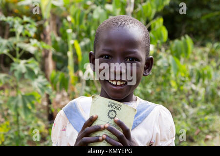 Una sorridente ragazza ugandese in possesso di un notebook. Foto Stock