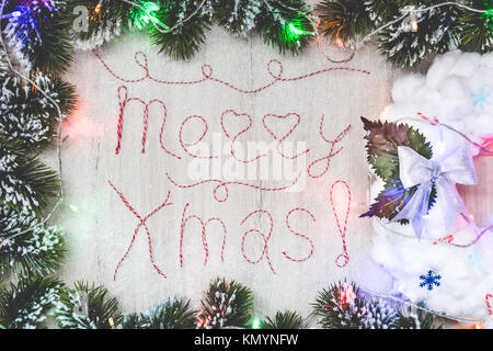 Le parole 'Buon Natale' fatta da rosso e il filo bianco lettere su legno texture con decorazione di Natale Foto Stock