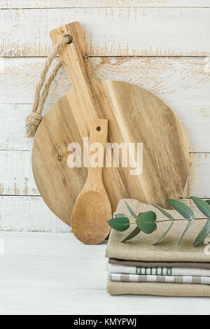 Rotonda di Legno artigianale Tagliere cucchiaio pila di biancheria da letto di cotone asciugamani da cucina sul tavolo bianco scandinavo stile Provenza Kinfolk sito web dello Store Banner Te Foto Stock