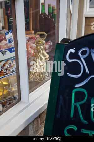 Una serie di vecchio stile imperiale di ottone pesi sul display nella finestra di un mercato comune delle macellerie shop Foto Stock