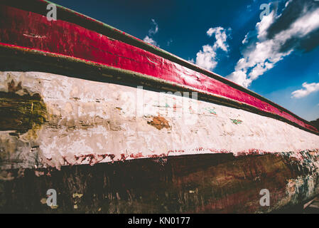 Vecchio di età compresa la barca di legno tirato oltre il mare per la manutenzione di vernice. Legno texture di colore Foto Stock