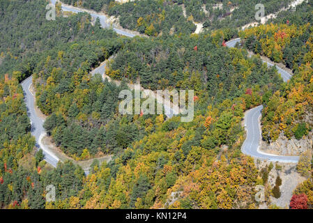 Vista aerea del serpeggiante strada di montagna zigzagando attraverso la foresta di autunno a Taulanne, vicino Castellane, Verdon Parco Regionale, Provenza Foto Stock