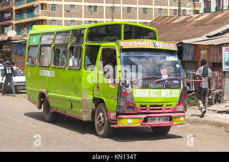 Un vivacemente colorato autobus verde di guidare su strada, Nairobi, Kenya, Africa orientale Foto Stock