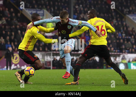 Burnley's Johann Berg Gudmundsson (centro) battaglie per la sfera contro Watford Christian Kabasele (sinistra) e Watford's Abdoulaye Doucoure durante il match di Premier League a Turf Moor, Burnley. Foto Stock