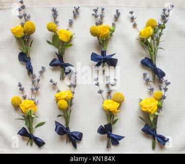 Vista ingrandita della decorazione floreale per cerimonia di nozze e la celebrazione. Bella diversi piccoli corsages fatta di bianco, giallo, verde e fiori di colore blu. Fla Foto Stock