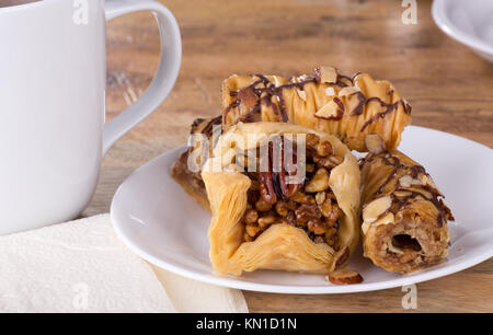 Il Baklava pasta dolce su una piastra bianca con tazza di caffè Foto Stock