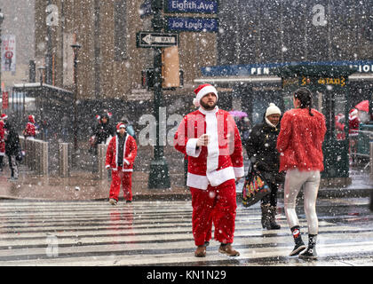 New York, Stati Uniti d'America, 9 Dic 2017. La gente vestita come Babbo Natale arriva per una festosa 'Santacon' folla raccolta sotto una tempesta di neve. Foto di Enrique Shore/Alamy Live News Foto Stock