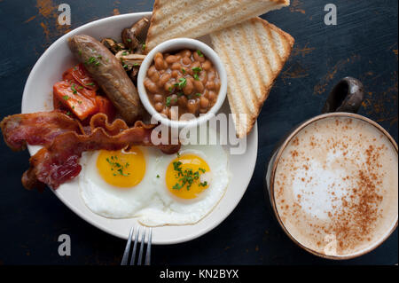 Il cibo una classica colazione inglese completa di uova pancetta o salsiccia bangers fagioli funghi pomodori e toast con caffè