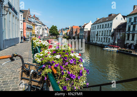 Ghent, Belgio - 29 agosto 2017: Biciclette parcheggiate e vaso di fiori lungo il fiume Leie nella città medievale di Gent, Belgio Foto Stock