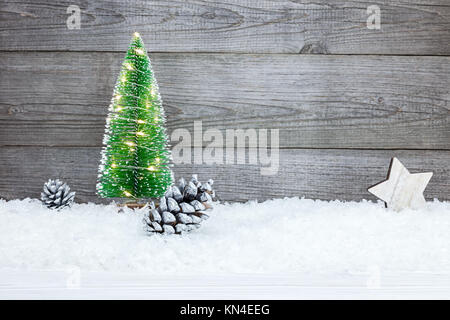 Natale abete con decorazioni su grigio rustico in legno tavole Foto Stock