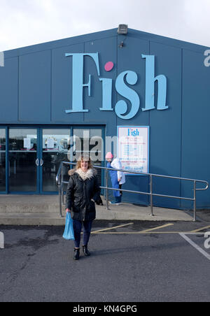 Shopper femmina lasciando il pesce ben note fresche pescivendoli shop a Shoreham harbour BRIGHTON REGNO UNITO Foto Stock