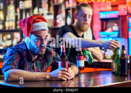Uomo ubriaco in pub per Natale Foto Stock
