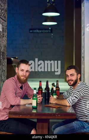 Due amici a bere birra nel bar Foto Stock