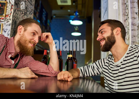 Due amici ubriachi parlando in bar Foto Stock