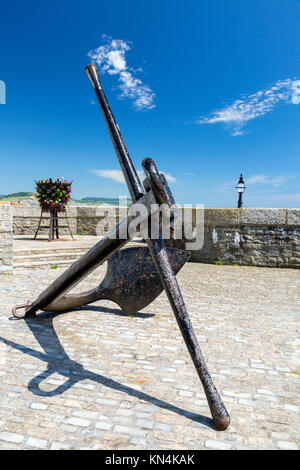 Un lungomare basket fuoco con fiori e nave storica di ancoraggio a Lyme Regis su Jurassic Coast Sito Patrimonio Mondiale, Dorset, England, Regno Unito Foto Stock