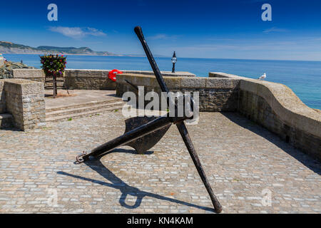 Un lungomare basket fuoco con fiori e nave storica di ancoraggio a Lyme Regis su Jurassic Coast Sito Patrimonio Mondiale, Dorset, England, Regno Unito Foto Stock