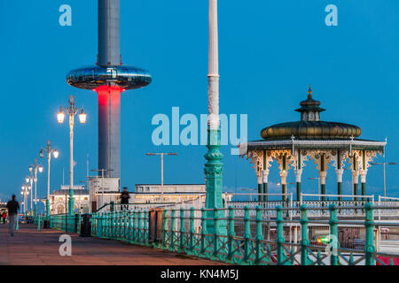 La notte scende sul lungomare di Brighton, Regno Unito. Victorian Bandstand e i360 torre in distanza. Foto Stock