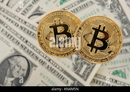 Immagine simbolo cryptocurrency, valuta digitale, golden moneta fisica Bitcoin sul dollaro Usa banconote Foto Stock