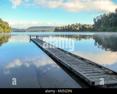 Il Cloud riflessioni la mattina presto, Lago Mapourika, Isola del Sud della Nuova Zelanda Foto Stock