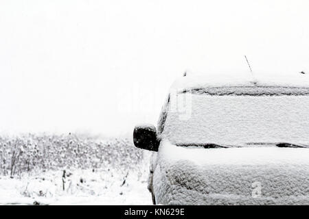 Dettaglio di un auto sulla strada durante la caduta di neve in inverno Foto Stock