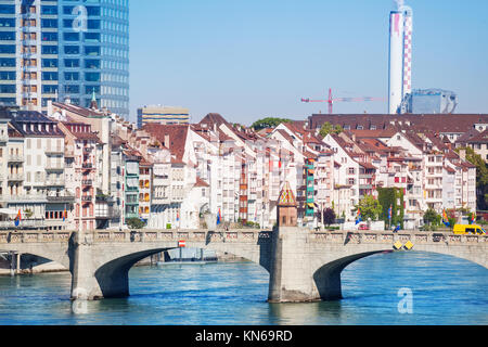 La città di Basilea con pietra arcuata di mezzo ponte che attraversa il fiume Reno in primo piano Foto Stock