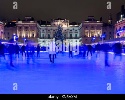 I pattinatori godendo la pista di pattinaggio su ghiaccio a tempo di Natale a Somerset House Foto Stock